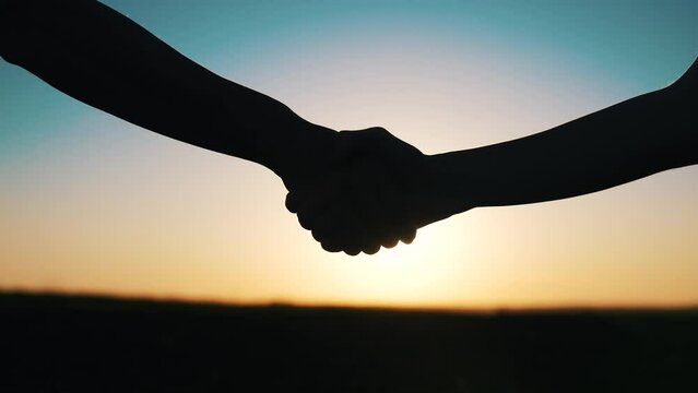 handshake farmers silhouette. agriculture business concept. close-up farmers hands silhouette shaking hands silhouette making a contract agreement. farmers negotiations in sun agriculture business