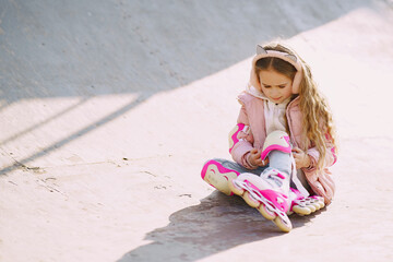 Mother with daughter in a spring park with rollers