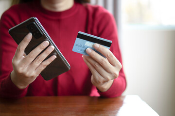 Close up woman hands holding mobile smart phone and credit card, using banking service, online shopping.