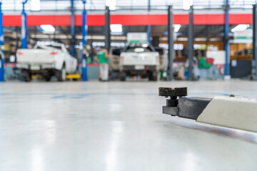 Select focus equipment electric lift for cars in the service put on the epoxy floor in new car factory service , Car repair service center blurred background for industry.