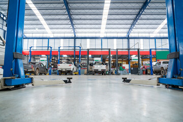 An electric lift for cars in the service put on the epoxy floor in new car factory service , Car repair service center blurred background for industry