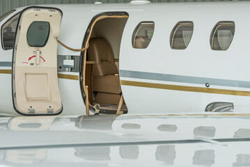 Stairs and door of a small private jet in hangar ready to fly- stock photo