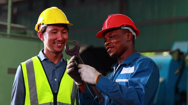 Training trainee concept. Caucasian male engineer explain the procedure for using the correct metal robot machine at lathe industrial factory.