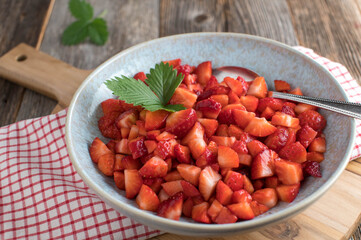 Bowl with fresh chopped and marinated strawberries