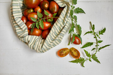 Fototapeta na wymiar Market delivary of brown tomatoes in eco textile bag, Zero waste, Eco background, Assortment of tomatoes, local farmers market, Fresh vegetables, harvest .Top view, copy space.