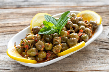 Green olive. Olives with special sauce on wood background. Healthy food. close up