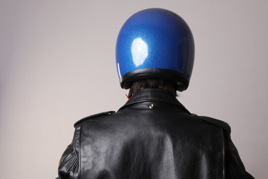 Back View Of Motor Biker Man Posing With Blue Helmet On White Wall. Mock-up.