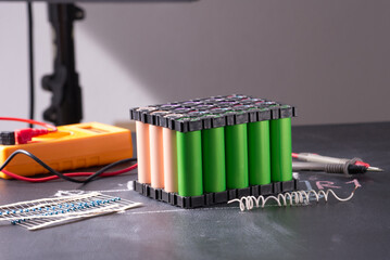 Lithium battery pack in black plastic holder on dark background.