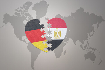 puzzle heart with the national flag of egypt and germany on a world map background. Concept.