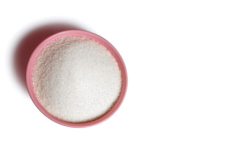 Pink deep plate with white sugar on an isolated white background. Sugar as an ingredient in cooking. Top view bowl with sugar. Free space for text