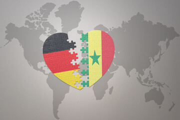 Fototapeta premium puzzle heart with the national flag of senegal and germany on a world map background. Concept.