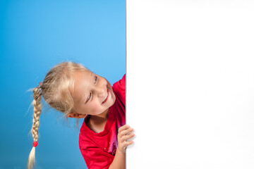 A cute mischievous girl peeks out from around the corner. White empty space for advertising. Poster mockup for website, sale page template.