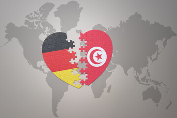 puzzle heart with the national flag of tunisia and germany on a world map background. Concept. - obrazy, fototapety, plakaty