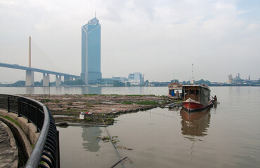 Chao Phraya River include modern tower and public boat, It's the major river in Thailand, with its low alluvial plain forming the centre of the country