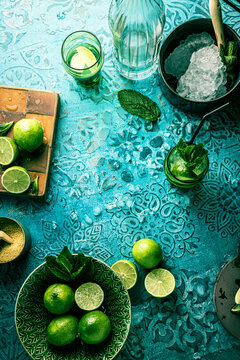 Fresh Mojito cocktail with lime, mint and ice in jar glass on dark blue background