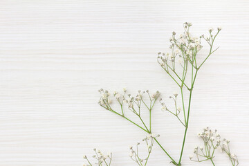 白い木目の上に置かれたかすみ草