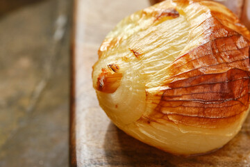 Grilled vegetables platter. Baked onion on a wooden board. Shallow depth of field