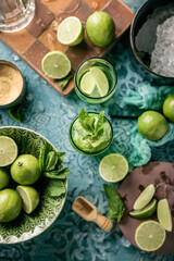 Fresh Mojito cocktail with lime, mint and ice in jar glass on dark blue background