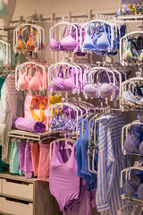 Lingerie store, female swimwear on hangers, sale in shop, summer assortment in clothing store, beach shop