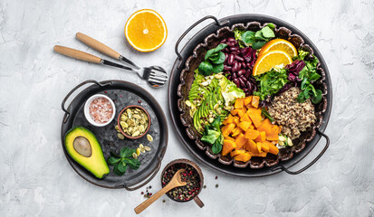 Quinoa salad in bowl with avocado, sweet potato, beans on gray background. superfood concept. Healthy, clean eating concept. Vegan or gluten free diet. top view