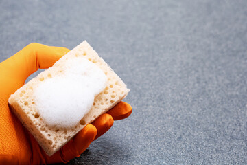 Hand Holding Cleaning Sponge Against Tiles Backgroung With Copy Space. Cleaning Concept.