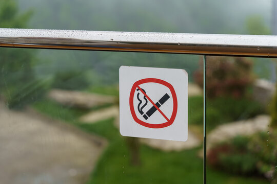 Do not smoke sign on glass fence. Selective focus.
