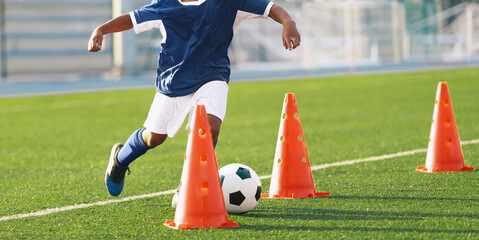 Soccer ball control exercises for kids. Child playing soccer ball on practice unit. School physical...