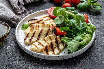 Grilled Halloumi cheese salad on white plate, Cyprus squeaky cheese. Restaurant menu, dieting, cookbook recipe top view