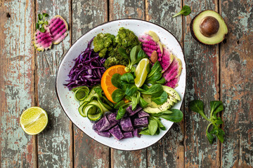 bowl salad with halloumi cheese, avocado, cucumber, chickpeas, watermelon radish, potato purple sweet. Buddha bowl, healthy and balanced food. top view