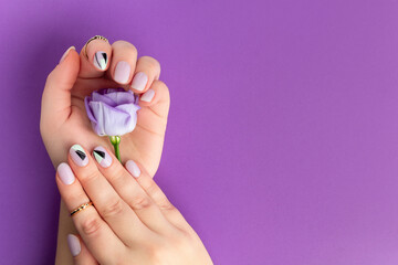 Beautiful womans hands with spring summer design on violet background. Manicure, pedicure beauty salon concept