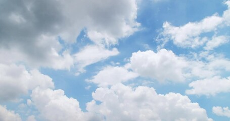 White puffy clouds and blue sky time-lapse with long second duration for background and graphics in daylight.