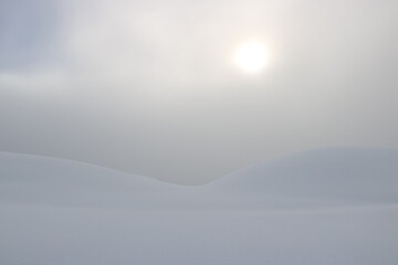 le disque de l'astre solaire dans la brume matinale en montagne, jour blanc  