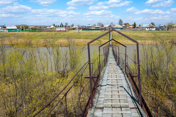 Suspended pedestrian bridge over the Yaya River in the village of Nasha Rodina