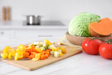 Different raw vegetables on white marble table in kitchen