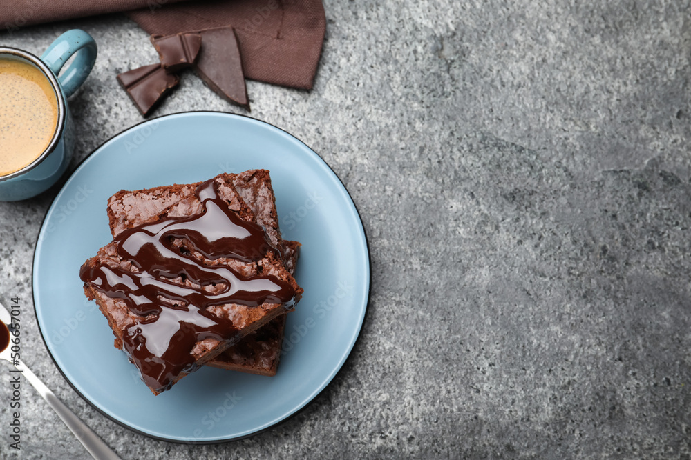 Canvas Prints Delicious chocolate brownies with sweet syrup served on grey table, flat lay. Space for text