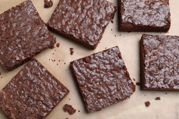 Delicious chocolate brownies on parchment paper, top view