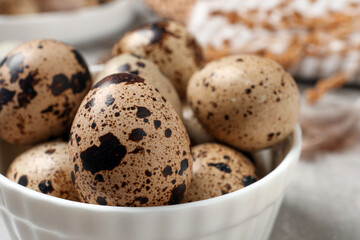 Fresh quail eggs in bowl on table, closeup