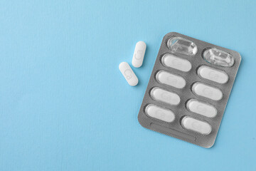 Blister pack with calcium supplement pills on light blue background, flat lay. Space for text