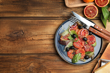 Delicious sicilian orange salad served on wooden table, flat lay. Space for text
