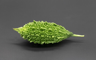 single Bitter melon or Bitter gourd isolated on black background