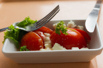 Eggs, cheese, tomatoes in salad. Healthy keto food. Hospital  and restaurant meal.  Nutrition  from vegetables and meat. Fresh oranges and clementines. Vitamins and trace minerals and phytonutrients.