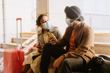 Indian couple talking and using mobile phones in airport
