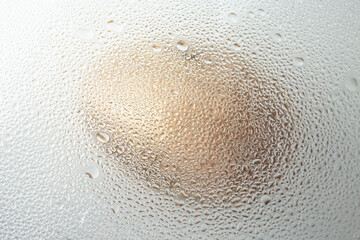 macro shot of an golden egg seen through water droplets