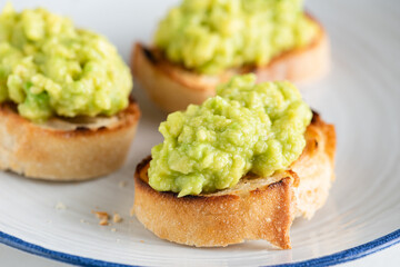 Vegan avocado bruschetta or mini toasts. Healthy appetizer or snack. Closeup view
