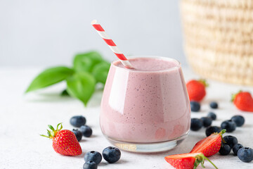 Delicious pink berry fruit smoothie in glass. Healthy vegan smoothie or vegan milkshake with soy...