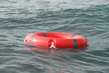 Life ring in ocean. Red lifebuoy in sea. Life ring floating in water. Red life preserver in see