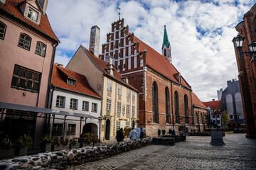 Obraz premium Riga, Latvia, 14 October 2021: St. John's Church, UNESCO heritage in Baltic states, Northern Gothic Style with Red brick and spire, recognizable medieval landmark at old town at sunny day