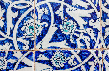 Close up of hand painted blue tiles with a flower motif on the facade of a madrassa in Khiva, Uzbekistan, Central Asia