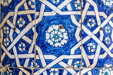 Close up of hand painted blue tiles with a flower motif on the facade of a madrassa in Khiva,...