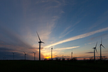 Windräder als Silhouette im romantischen Sonnenuntergang auf einem Feld - Sachsen-Anhalt in Deutschland